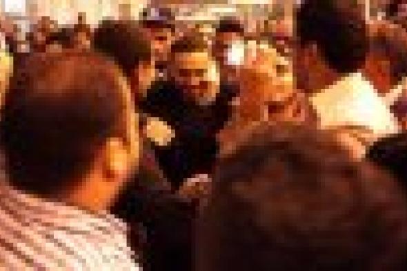 بالصور: جمهور تامر حسني يستقبله بالورود واللافتات في مطار القاهرة